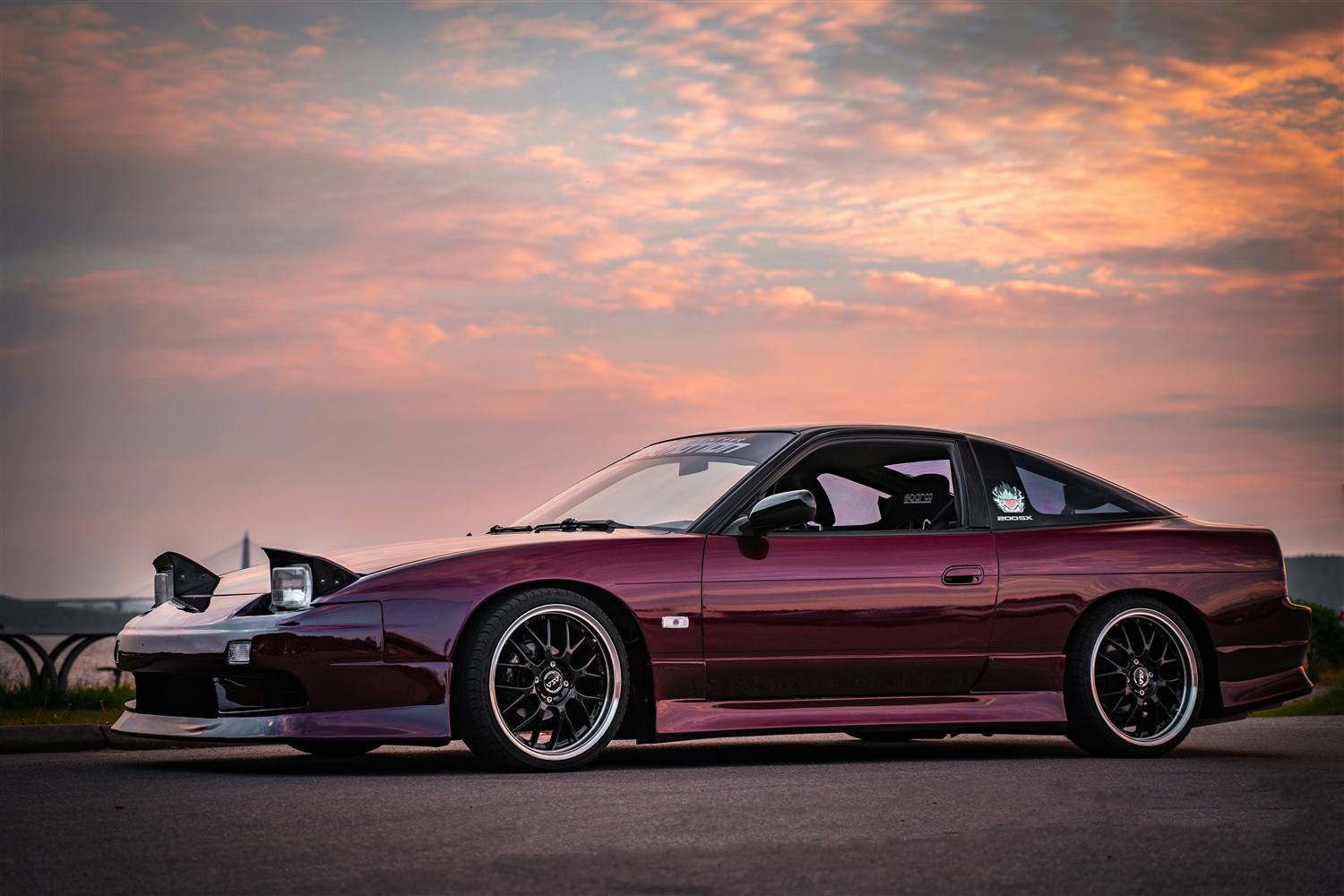 Deep purple Nissan 180SX parked by the water at sunset